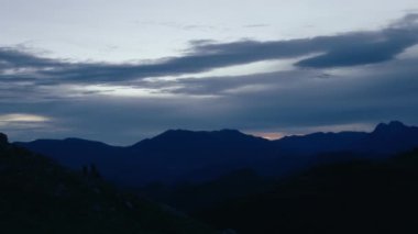 Landscape scenery of dusk sunset in mountains. Majestic blue sky and clouds over beautiful tops of the hills. Dramatic sunset or sunrise moment 
