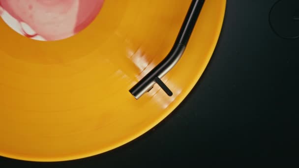 Top View Black Stylus Smoothly Rolling Orange Glossy Vinyl Record — стоковое видео