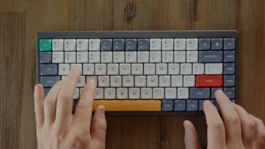 Hacker hands nervously hit buttons on keyboard lying on the wooden table. Expert at programming and solving problems using computer system to access information or find correct hotkey combination.