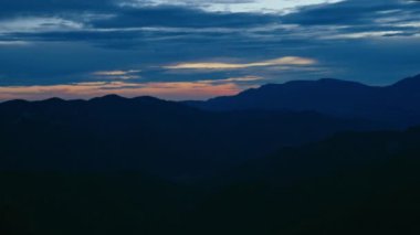 Landscape scenery of dusk sunset in mountains. Majestic blue sky and clouds over beautiful tops of the hills. Dramatic sunset or sunrise moment 