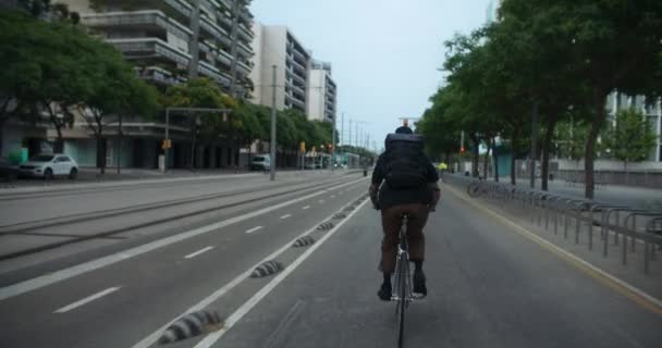 市内の若い男の自転車に乗るのショットに従ってください 自転車レーン上 自転車のための都市計画インフラ 時間内に到着するまでの速度 環境に優しく効率的な交通機関の選択 — ストック動画