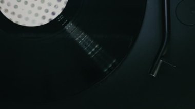 Müzik stüdyosundaki klasik ve şık vinil plak çaların tek renkli yakın çekim görüntüsü. Siyah turntable stili gider ve nazikçe parlak diske iğneyle dokunur. Disko partisi. Metin için boşluk. 