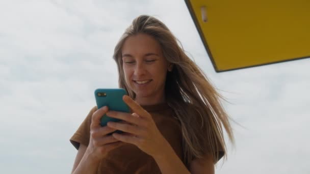 Con Una Sonrisa Cara Joven Escribe Mensaje Teléfono Contra Telón — Vídeos de Stock