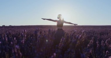 Spordaki hayalperest kız gün doğumunda lavanta tarlalarında meditasyonal yoga asanas giyer. Gezgin şehvetine ilham verir. Savaşçı poz pratiği. Esneme egzersizleri. Sağlıklı yaşam tarzı blogcusu veya modeli. 