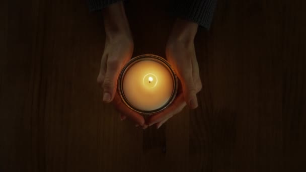 俯瞰女性的手抱着蜡烛保暖 神圣圣礼的精神意义带来了和平与沉思 激励了祈祷 女人把手从蜡烛上移开 神奇时刻 — 图库视频影像
