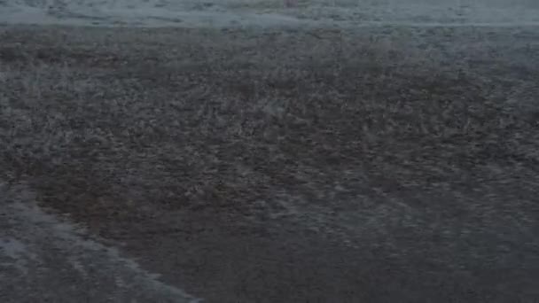 荒天時には波が海岸を横切る 巨大な波 バック海に石や砂を引っ張っロールビーチヒット ムーディー手持ちの雨の日ショット — ストック動画