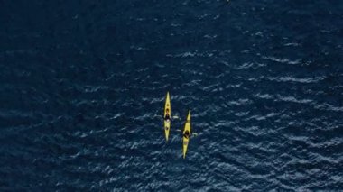 Norveç fiyordunda, derin mavi okyanus suyunda yüzen iki parlak sarı tek kanonun üst görüntüsü. Destansı ve ilham verici aktif yaşam tarzı macera konsepti ve fikri. Doğanın sağlıklı spor keşfi