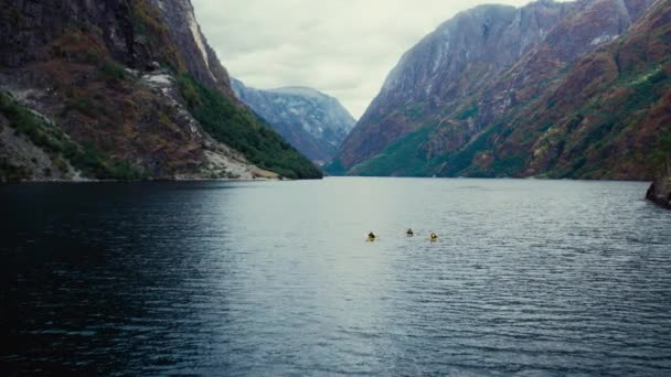 Группа Друзей Жёлтых Байдарках Гребут Величественном Норвежском Фьорде Воздушный Беспилотный — стоковое видео