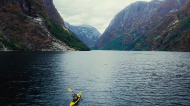 Norveç 'te destansı güzel fiyortta üç sarı kano kürek çekiyor. Açık hava macerası. İskandinavya 'da aktif tatil ve tatil