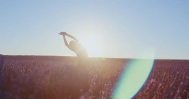 Gün doğumunda lavanta tarlalarında, kadın spor giysilerinde yoga güneşi selamı verir, meditasyondan ilham alır. Esneme ve egzersiz rutini ilham için mükemmeldir. Rüya gibi manzaralı. 