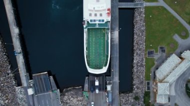 Yolcu ve araç feribotları vagonları ve kamyonları yüklüyor. Denizdeki lojistik operasyonların insansız hava aracı görüntüsü. Deniz donanması taşımacılığı