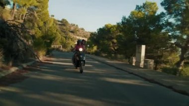 Altea, İspanya - Mayıs 2021. İki mutlu kız arkadaş Vespa 'nın kırsal kesimlerini keşfediyor, manzaralı yolların tadını çıkarıyor ve hedeflerine gülümseyerek ulaşıyorlar. Küçük bir köyde yaz tatili. 