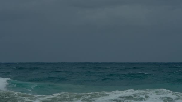 嵐の海の風景のフロントショット 海岸に対して強力な波が衝突し 危険で劇的なシーンを作り出します 暗い空と乳白色の泡は自然の力を強調しています 青い地平線 — ストック動画