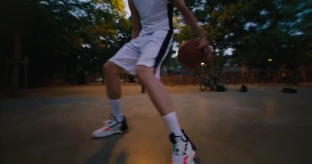 Akşamları Iki Basketbolcunun Park Sahasında Oynamalarının Düşük Açılı Çekimi Maçı — Stok video