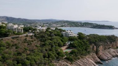 Üzerinde tenis kortu olan lüks bir emlak villası olan kayalık sahil şeridinin insansız hava aracı görüntüsü. Gözlerden uzak bir spa oteli ya da dinlenme merkezi. Güney Avrupa 'da serin ve rahatlatıcı bir yaz tatili.
