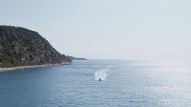 Beyaz yelkenli, motor gücüyle sahilin yanındaki kameraya doğru sürükleniyor. Yat ya da tekne kiralama. Yazın açık hava aktivitesi. Lüks bir yelkenli. Güney Avrupa 'da güzel bir yaz tatili.