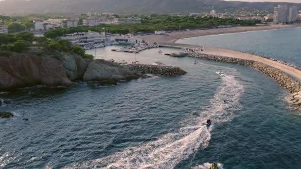 摩托艇和喷气式滑雪板滑板车的无人驾驶飞机镜头进入港口 高速水上运动 南欧高山海岸的壮丽景色 暑假活动 — 图库视频影像
