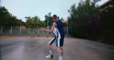 İki rakip yaz günü parkta sokak basketbolu oynuyor. Dostça bir rekabet ya da uygulama. Bir oyuncu diğerini engellemeye çalışıyor, atışı kaçırıyor, fırsatı kaçırıyor. 
