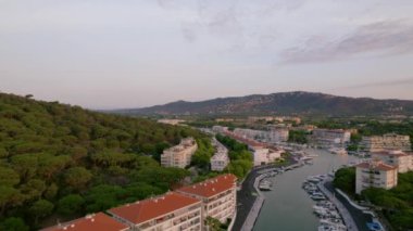 İnsansız hava aracı marina üzerinde küçük tekne ve yatlarla hareket ediyor. Etrafı konut evleriyle çevrili. Yaz tatili gayrimenkul. Dağ vadisine kurulmuş bir köy. Deniz kentinde lüks özel liman. 