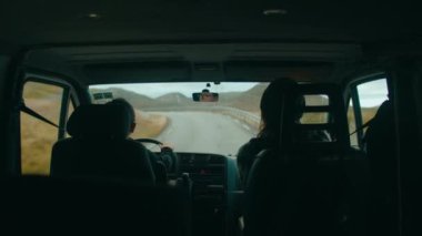 Arka koltukta Norveç dağ yolunda karavan içinde seyahat eden çiftlerin fotoğrafları var. Macera yolculuğu konsepti. Vanlife açık hava yaşam tarzı. Hayat yollarda