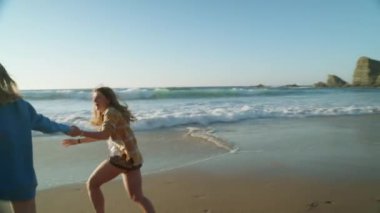 Sinematik bir anda, iki bin yıllık arkadaş doğal, el değmemiş bir plaj boyunca çıplak ayakla koşar, kahkahaları saf arkadaşlığın özünü yansıtır. Yeni neslin özgürlük yolculuğu yaşam tarzı