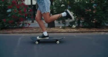 Asfaltlı zeminde kaykay yapan genç kadınların el kamerasıyla çekilmiş resimleri. Kaykaycı kız yere güçlü ve kendine güvenle bas.. 