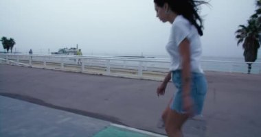 Genç bayan patenci zemini itiyor ve süratli kaykay sürüyor. Milenyumların modaya uygun, modern yaşam tarzı. Profesyonel kaykaycı hafta sonu geldi. Kadın gücü. 