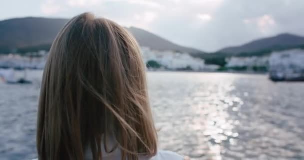 码头的女游客的画像 女孩转身对着相机笑了 阳光在她的头发上闪烁着 柔和的海风 在暑假期间 地中海沿岸带来了满足感 快乐和自由感 — 图库视频影像