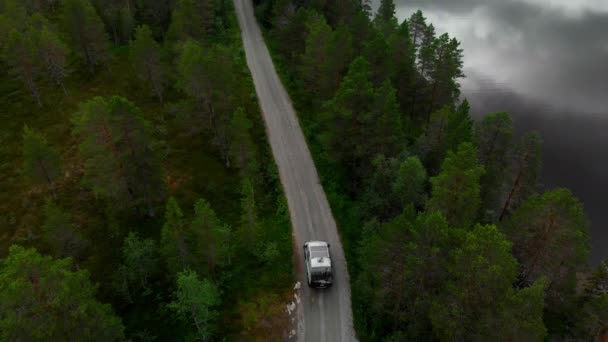 国立公園の壮大な周辺で未舗装の土道で冒険キャンピングカーバンドライブのシネマティックドローンショット ノルウェーの森で自動車を変換した道路の外側のキャンパーバン — ストック動画