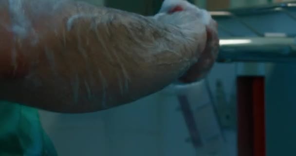 がん性腫瘍除去手術の主な外科医は手袋やスクラブを着用する前に手と腕を徹底的に洗浄します ルームルーチンとルール — ストック動画