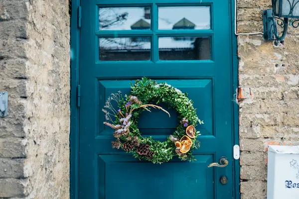 木製のドアとクリスマスリース付きのスカンジナビアスタイルの家への美しい入り口 自家製デンマークXmasデコレーション 冬の街のドアと風景 冬の装飾とノルディックなライフスタイルをインスパイア ロイヤリティフリーのストック写真