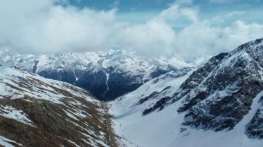 Dağ vadisinde yükseklerde, dağ sırasına doğru uçan kameranın hava aracı görüntüsü.