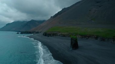 İzlanda 'daki Laekjavik plajının hava görüntüsü, kıyı şeridindeki dev siyah kaya oluşumu. Huysuz ve kasvetli karanlık seyahat yeri