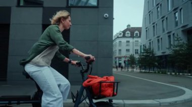 Şirin, tapılası ve şık genç bir kadın kargo elektrikli bisikletiyle şehirde pedal çeviriyor. Sıcak bir yaz sabahında iş bölgesinde öğrenci ya da yaratıcı ofis çalışanı döngüsü