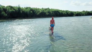 Genç bir adam, köpek sahibi, köpeğiyle birlikte dağlardaki nehir kıyısında koşuyor. Kırsal kesimdeki aile kamp yeri. Saf otantik yaz eğlencesi. En iyi arkadaş takılması. 