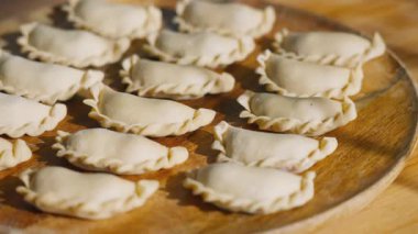 Tertemiz ve kaynatılmaya hazır, ahşap tabakta kiraz dolu hamur tatlısı. Gıda blogcusu veya tarif şefi sosyal medya içeriği