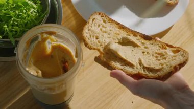 Humus, roka ve karamelize armutla kaplı lezzetli bir buğday ekmeği hazırlama ve servis etme süreci.. 