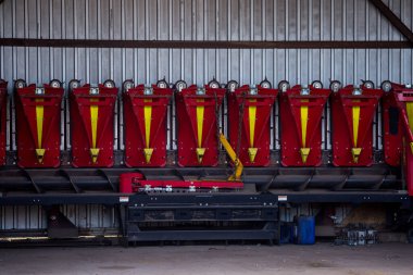 Mısır kafa hasatçısı, tarım işletmesinin malzeme ve teknik üssünün kemer hangarında duruyor. Ukrayna 'nın orta kesimindeki tarım işletmeleri.