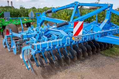 Tarımsal girişimin maddi ve teknik temelinde uzun mısır sapları ve ayçiçeği kalıntılarının bulunduğu bölgelerde ekin ekimi için disk harrow. Ukrayna 'nın orta kesimindeki tarım işletmeleri.