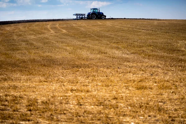 一辆配有可复耕犁和剥皮辊的现代蓝色拖拉机正在犁田 春天的谷物刚刚收获 乌克兰中部仲夏 — 图库照片