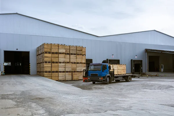Cargo terminal of the logistics center. The truck in which the boxes are loaded. Stacked up empty pallets boxes. Ramp for loading. Supply chain management of finished products in industrial production