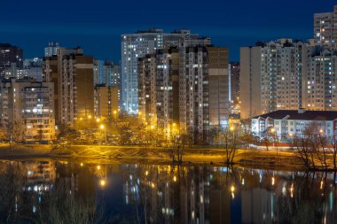 Büyük şehrin gece manzarası. Boş sokaklardaki parlak, çok renkli ışık. Yatak odası civarındaki apartmanlar. Kyiv, Mart 2024 'ün sonunda. Ukrayna.