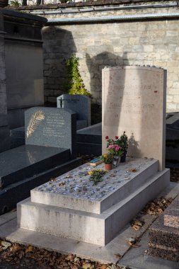 A grave of Jean-Paul Sartre and Simone de Beauvoir on Montparnasse Cemetery, Paris, France. A famous couple, was of the most influential and controversial writers and thinkers of the 20th century clipart
