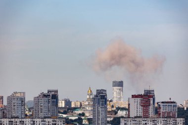 Kyiv, Ukraine - July 08 2024: Smoke rises over the city skyline after Russian combined missile strike to the civilian infrastructure of the capital city of Ukraine. Russian war aggression in Ukraine clipart