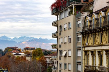İtalya, Torino 'daki binalar, karla kaplı Alpler' in manzaralı arka planı. Dağ manzaralı şehir manzarası.
