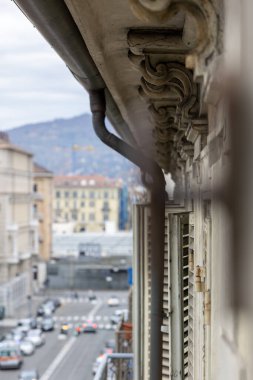 Torino, İtalya 'da mimari detayların yakın plan çekimleri, süslü taş işçiliği. Bulanık şehir manzarası arka planda bağlam sağlar.