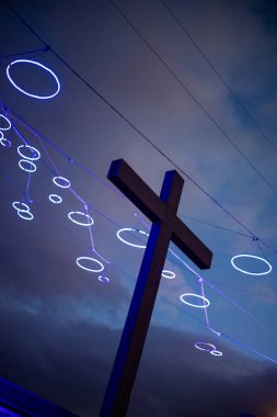 İtalya 'nın Torino kentindeki Chiesa di Santa Maria del Monte dei Cappuccini yakınlarında aydınlatılmış haç modern neon süslemeleriyle gece gökyüzüne karşı duruyor. Şehir gece sahnesi.