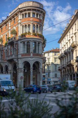 Torino, İtalya - 08 Kasım 2021: Palazzo Bellia yakınlarındaki dekoratif mimari bina kemerli kaldırımlar, balkonlar ve arabalı ve yaya geçitli bir şehir caddesinde detaylı tuğla işi