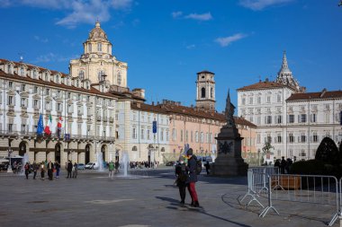 Torino, İtalya - 08 Kasım 2021: Palazzo Madama 'nın yer aldığı Piazza Castello, Kraliyet Sarayı, bir anıt, çeşmeler ve açık mavi gökyüzü altında ince bulutlu sayısız yayalar