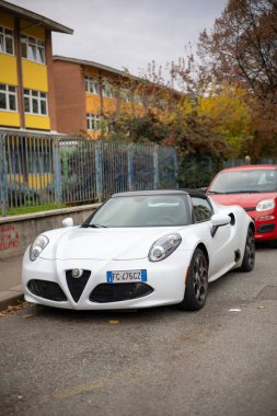Torino, İtalya - 08 Kasım 2021: Üstü açık beyaz Alfa Romeo 4C Spider spor arabası şehrin caddesine park edilmiş yumuşak siyah bir üstü var